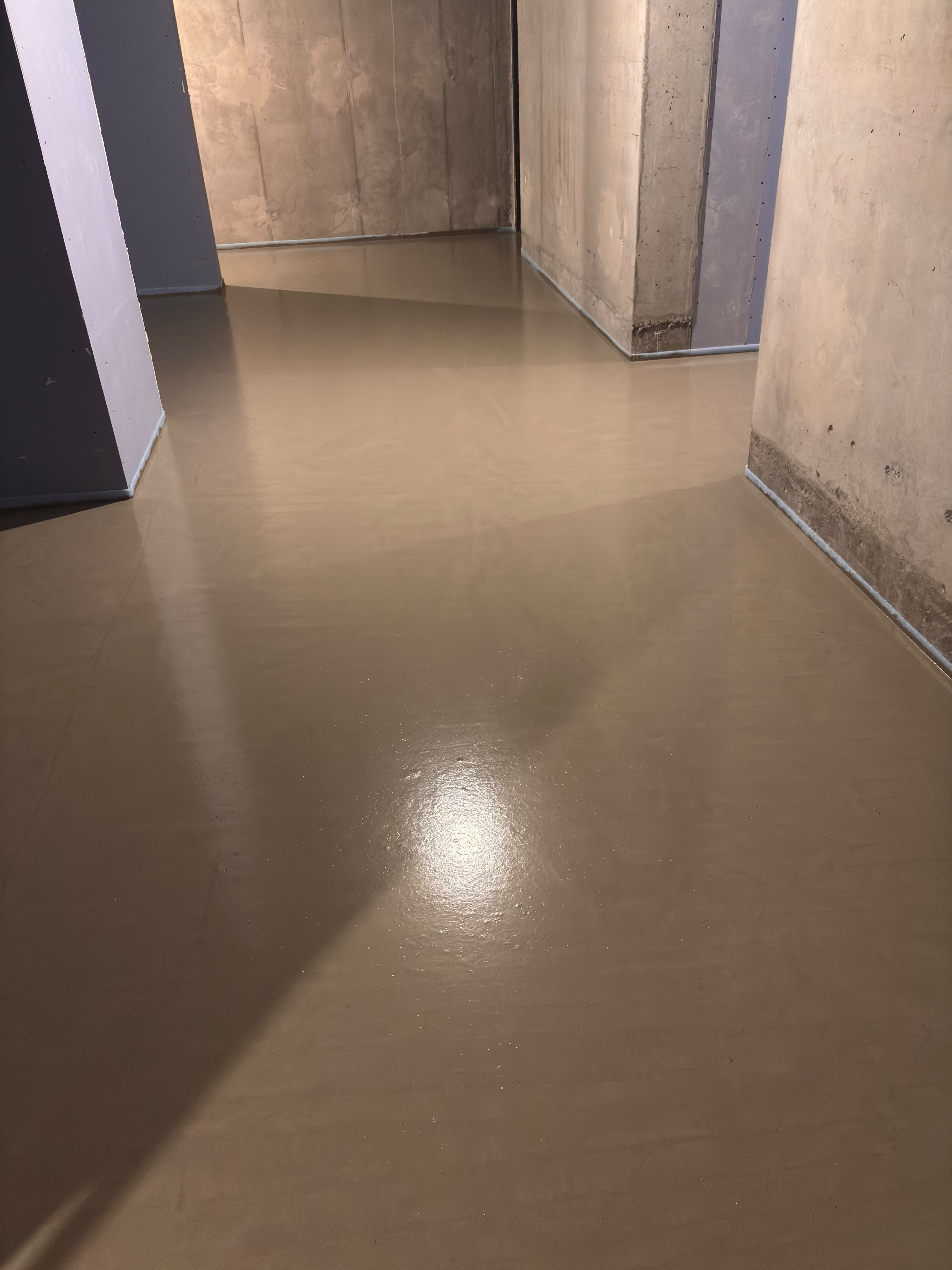 Vlakke vloer tussen onafgewerkte betonnen wanden en kolommen